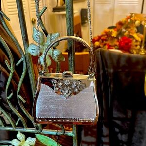 Mini silver metal bag with stone details.
